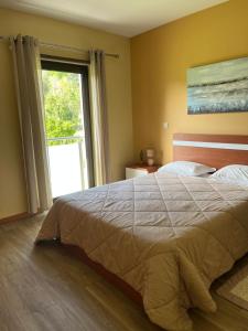a bedroom with a large bed and a large window at Casa D'avo in Geres +29 photos