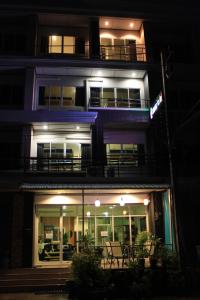 a night view of a building with a balcony at Ananas Central Phuket Hostel in Ban Ket Ho
