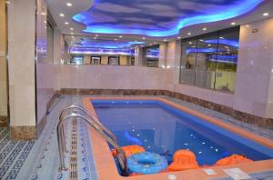 a swimming pool in a building with a blue ceiling at فندق جولدن نيو ارمادا جيزان - شركة ارمادا الورود الفندقية in Jazan