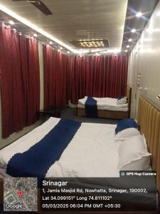 a bedroom with two beds and red curtains at Winter Wonder in Srinagar