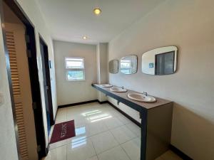 a bathroom with two sinks and two mirrors at Ananas Central Phuket Hostel in Ban Ket Ho