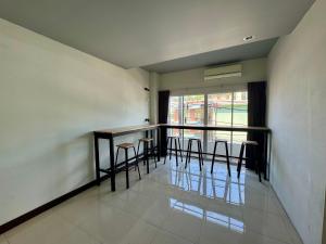 a room with a bar with chairs and a balcony at Ananas Central Phuket Hostel in Ban Ket Ho