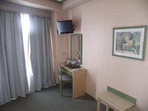 a room with a desk and a television in a room at Puente Romano in Ourense