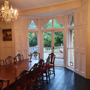 a dining room with a table and a large window at Country Manor House in Higham