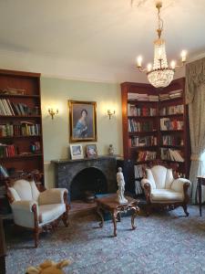 a living room with two chairs and a fireplace at Country Manor House in Higham +37 photos