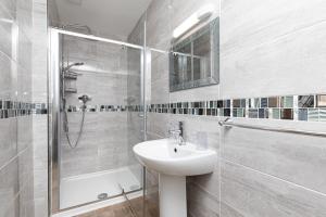 a white bathroom with a sink and a shower at The Annan Hotel in Llandudno +59 photos