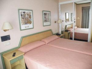 a bedroom with a pink bed and two beds at Puente Romano in Ourense