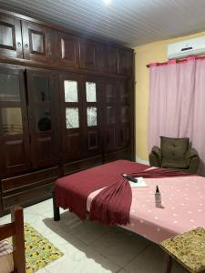 a bedroom with a bed with a red bedspread at Casa temporada maricá in Maricá