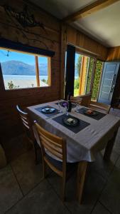 a dining room with a table with chairs and a window at Cabañas Los Maitenes in Villa Traful