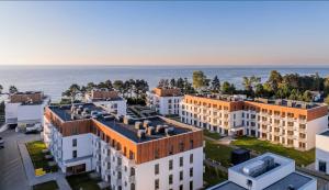 une vue aérienne de bâtiments avec l'océan en arrière-plan dans l'établissement APARTAMENT BlueSea Let`s Sea Baltic Park, à Gąski