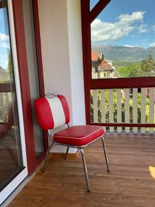 a red and white chair sitting on a balcony at Villa Bella Vita in Seeboden