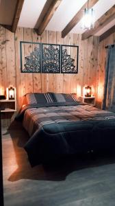 a bedroom with a large bed with wooden walls at Cabañas Los Maitenes in Villa Traful
