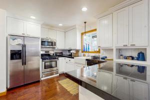 a kitchen with white cabinets and a stainless steel refrigerator at Babbling Brook in Lake Arrowhead