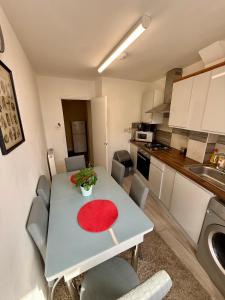 a small kitchen with a table with a red plate on it at Enormous Family Flat (7 guests) in London