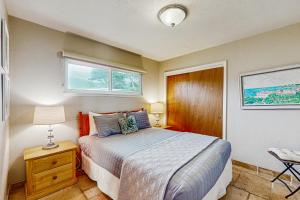 ein Schlafzimmer mit einem Bett, einer Lampe und einem Stuhl in der Unterkunft Cozy Carmet Cottage in Bodega Bay