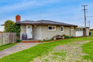 ein kleines Haus mit Rasen davor in der Unterkunft Cozy Carmet Cottage in Bodega Bay