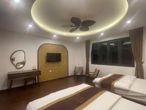 a bedroom with two beds and a ceiling fan at Maison Homestay Pho Bien 17, Ocean Park 3 in Ðình Loan +2 photos