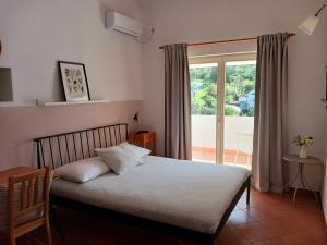 a bedroom with a bed and a large window at Apartmani Tia in Neum