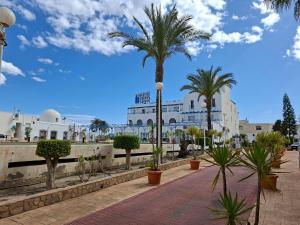 a street with palm trees in front of a building at Hotel Playa Bocaina in Mojácar
