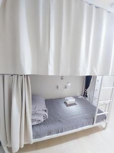 釜山FUNWAVE guest house的床上床,带窗帘的房间 更多105张照片