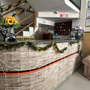 Residencial 9 de Septiembre في سانتا كروز دي لا سيرا: مكتب استقبال مع إناء من زهور الشمس