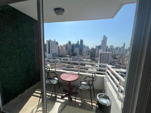 a balcony with two chairs and a table and a view at Acogedor apartamento en El Cangrejo in Panama City