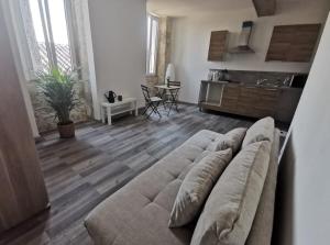 a living room with a couch and a kitchen at Maisonnette Cosy Montestruc sur Gers in Montestruc-sur-Gers