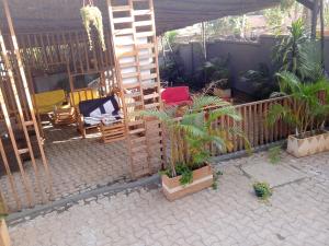 a garden with chairs and a wooden trellis at Noaz Hotel in Bulambiro