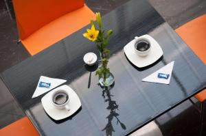 a black table with a vase with a flower in it at Hotel Ferias Park in Bogotá