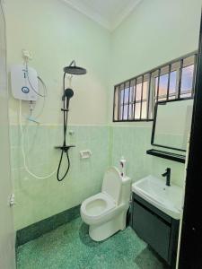 ein Badezimmer mit einer weißen Toilette und einem Waschbecken in der Unterkunft Homestay Deedora 87 in Seri Manjung