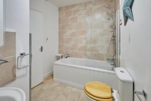 a bathroom with a toilet and a bath tub at Painters Modern Apartment Central Location in Scarborough +36 photos