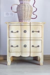 a wooden dresser with a basket on top of it at Hôtel La Villa Sainte Valérie Adults Only in Juan-les-Pins