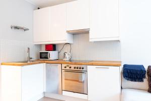 オスロにあるCentral and modern apartment at Frognerのキッチン(白いキャビネット、ステンレス製オーブン付)