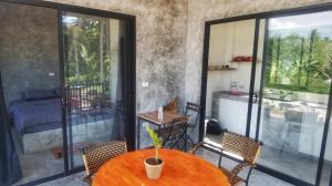 a dining room with a table and chairs on a balcony at Oscar bungalow in Ban Madua Wan