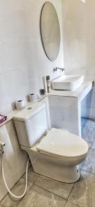 Un baño blanco con inodoro y lavabo. en Oscar bungalow, en Ban Madua Wan