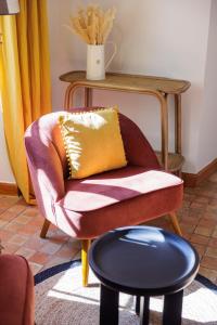 a chair with a yellow pillow and a table at Hôtel La Villa Sainte Valérie Adults Only in Juan-les-Pins