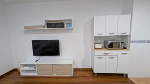 a living room with a tv and a white desk at Alojamiento La Caridad in La Caridad