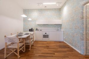 a kitchen with white cabinets and a table with chairs at Platessa in Portovenere