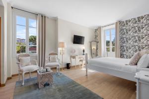 a bedroom with a bed and a table and chairs at Hôtel La Villa Sainte Valérie Adults Only in Juan-les-Pins