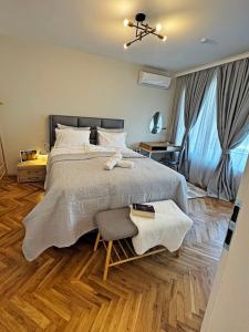 een slaapkamer met een groot bed en een stoel bij AURA BEACH apartment in Boergas