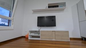 Una sala de estar con un televisor de pantalla plana en una pared. en Alojamiento La Caridad, en La Caridad