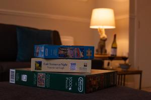 a stack of books sitting on top of a table at Painters Modern Apartment Central Location in Scarborough