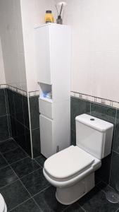 aseo blanco en un baño con azulejos negros en Alojamiento La Caridad, en La Caridad
