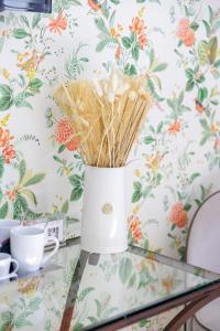 a vase on a table with straws at Hôtel La Villa Sainte Valérie Adults Only in Juan-les-Pins