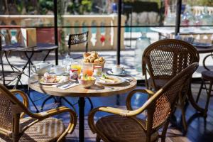 a table with food and drinks on a patio at Hôtel La Villa Sainte Valérie Adults Only in Juan-les-Pins