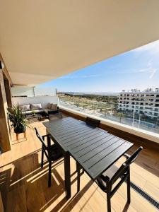 ein Balkon mit Tisch und Stühlen und einem großen Fenster in der Unterkunft Costa Blanca Beach Apartment in Arenales del Sol + 46 Fotos