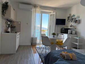 a kitchen and living room with a table and chairs at Villa Luka Apartman Pavo in Ston