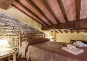 a bedroom with a bed and a stone wall at Wine Experience - Villa Aurora - Villa Diamante in Rignano sullʼArno