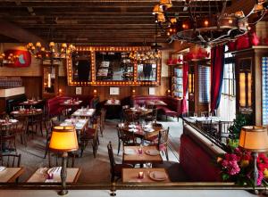 un restaurante con mesas y sillas en una habitación en The Ludlow Hotel en Nueva York