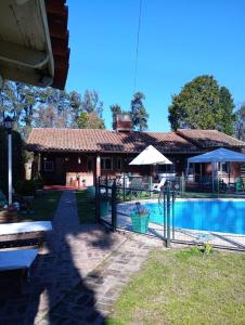 a house with a swimming pool in front of it at Quinta San Antonio in Luján